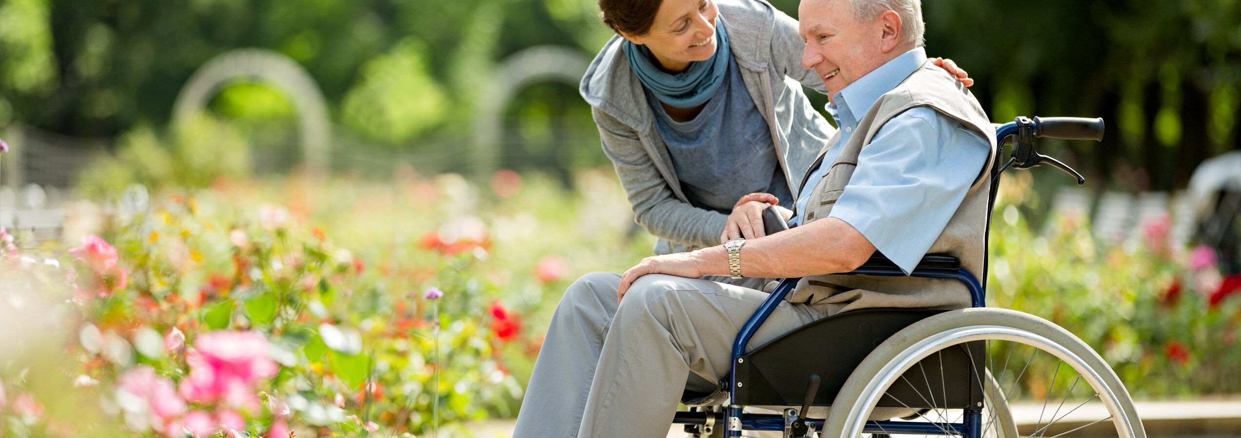 Seniorenbetreuung Jobs - Pflegerin und Rollstuhlfahrer lachend in einem Park | © Fred Froese/Getty Images iStock 599257344