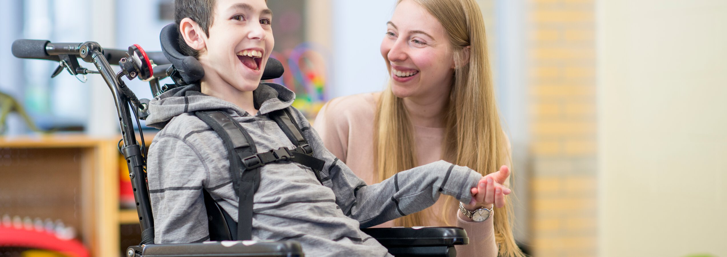 Ausbildung Heilerziehungspfleger - Junge Pflegerin und geistig behinderter Junge lachend und spielend | © FatCamera/Getty Images