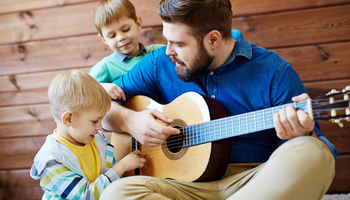 Caritas Erzieher musiziert mit Kleinkindern | © shironosov/Getty Images iStockphotos